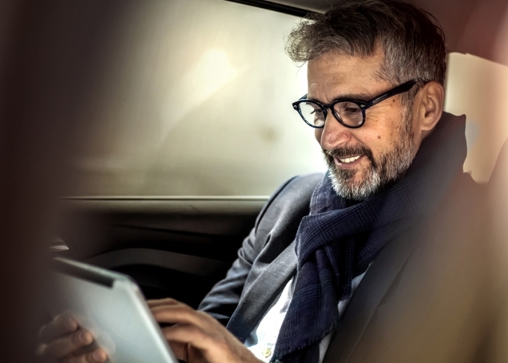 man in car looking at tablet